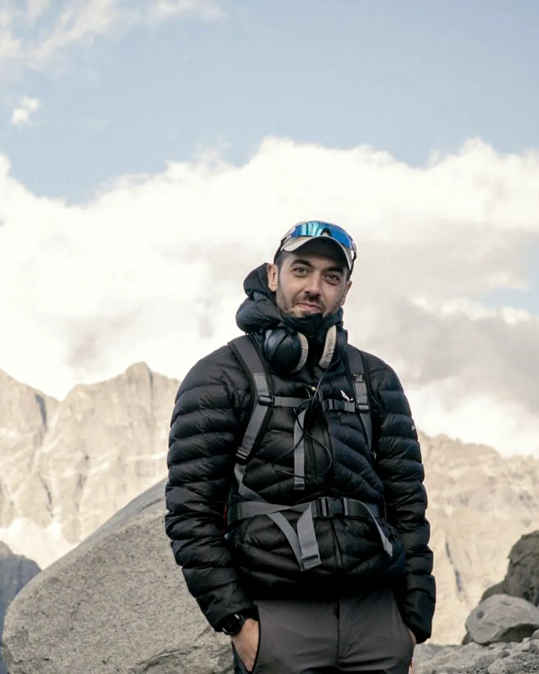 Andrea con cuffie e zaino davanti alle vette dell'Adamello