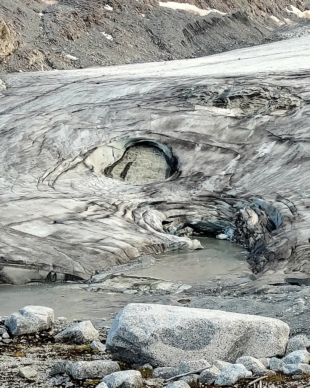 Grotta glaciale e acqua di fusione al fronte del ghiacciaio