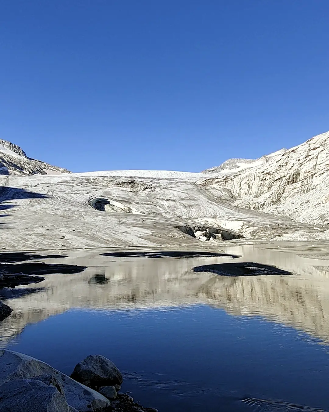 Lago glaciale che riflette il fronte del ghiacciaio