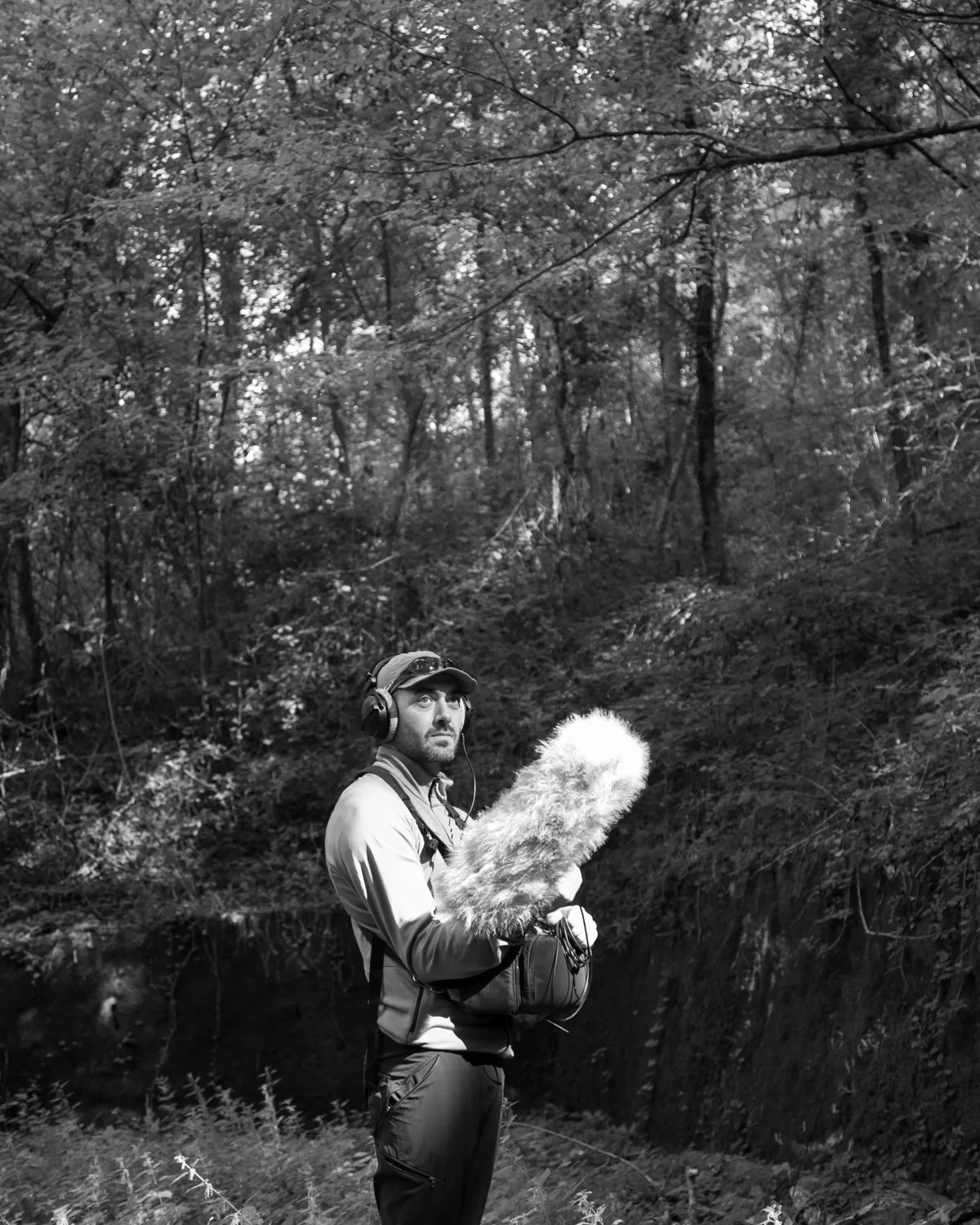 Andrea Peluso con microfono e cuffie durante una registrazione nel bosco