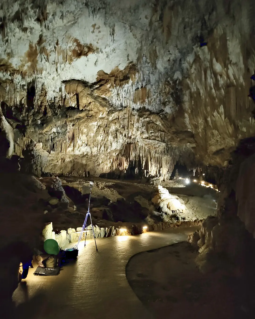 Grotta illuminata con microfono su treppiede lungo il sentiero