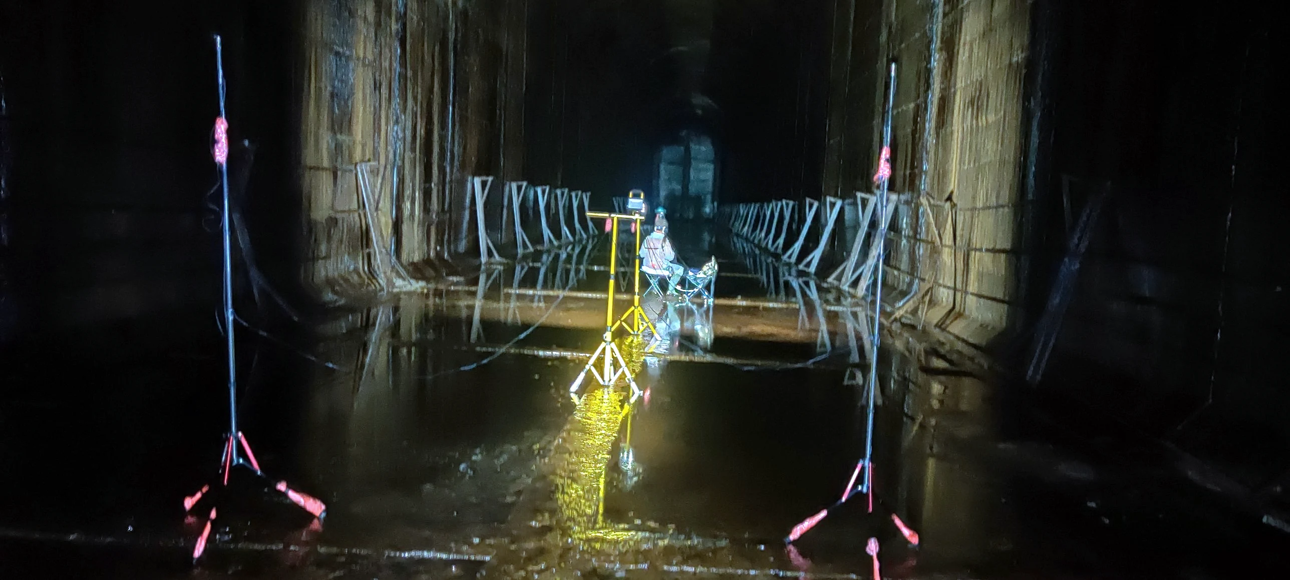 Microfoni su stativi e musicista nel tunnel allagato